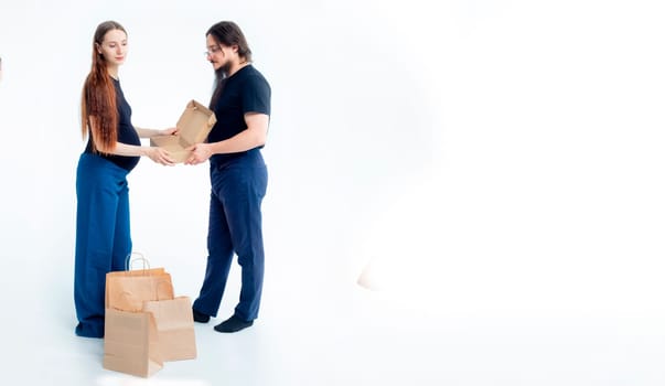 Portrait happy young pregnant woman and her husband with shopping bags and touching her big belly isolated on white background. Pregnancy shopping concept happy young family with shopping bags