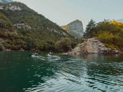 A group of friends enjoying having fun and kayaking while exploring the calm river, surrounding forest and large natural river canyons.