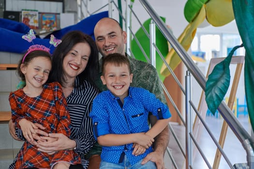 Portrait of a happy family. Photo of parents with children in a modern preschool classroom. Selective focus . High quality photo