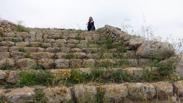 Sassari, Sardinia in Italy, May 18 2023. Staircase of the altar of Monte d'Accoddi in Sardinia. Tourists on the phone.