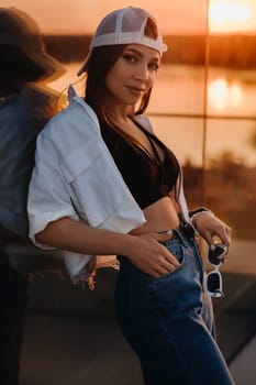 A young teenage girl in jeans and a cap walks around the city.