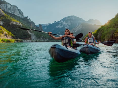 A group of friends enjoying fun and kayaking exploring the calm river, surrounding forest and large natural river canyons during an idyllic sunset