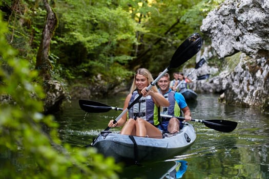 A group of friends enjoying having fun and kayaking while exploring the calm river, surrounding forest and large natural river canyons.