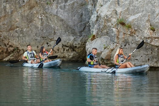 A group of friends enjoying having fun and kayaking while exploring the calm river, surrounding forest and large natural river canyons.