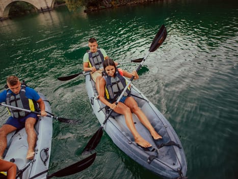 A group of friends enjoying having fun and kayaking while exploring the calm river, surrounding forest and large natural river canyons.