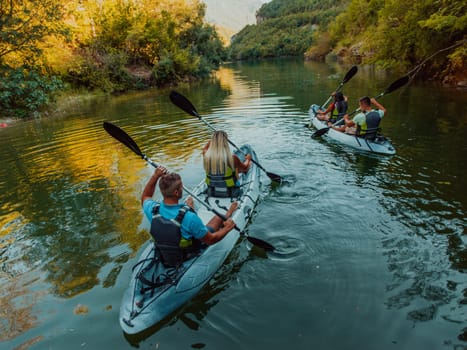 A group of friends enjoying having fun and kayaking while exploring the calm river, surrounding forest and large natural river canyons.