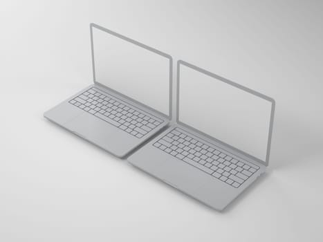 Two open modern gray laptops with blank screens on a light background
