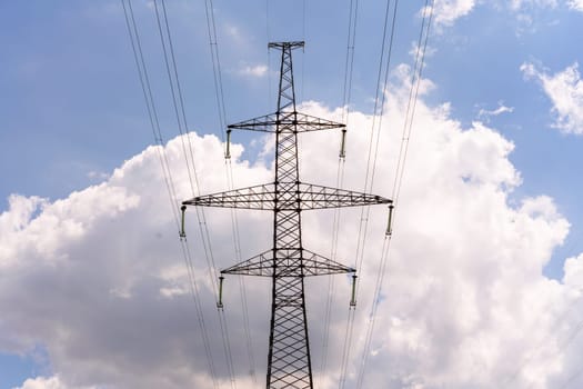 High voltage towers with sky background. Power line support with wires for electricity transmission. High voltage grid tower with wire cable at distribution station. Energy industry, energy saving.