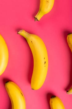 Directly above view of fresh bananas against pink background. unaltered, organic food and healthy eating concept.