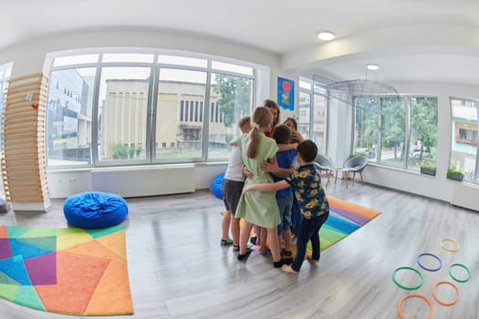 A child hugging a teacher in a modern kindergarten. High quality photo