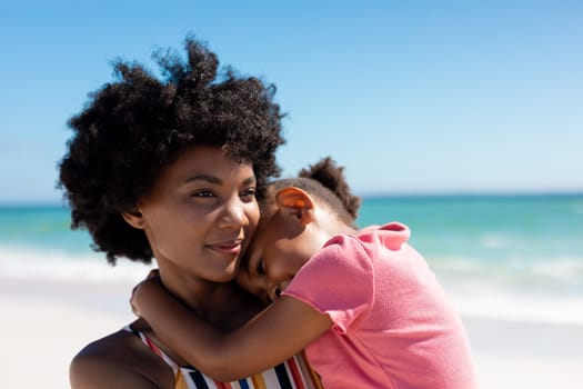 African american woman with daughter at beach enjoying summer weekend together. unaltered, family, lifestyle, togetherness, love and holiday concept.