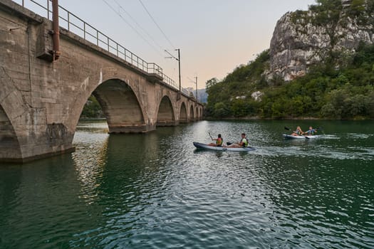 A group of friends enjoying having fun and kayaking while exploring the calm river, surrounding forest and large natural river canyons.