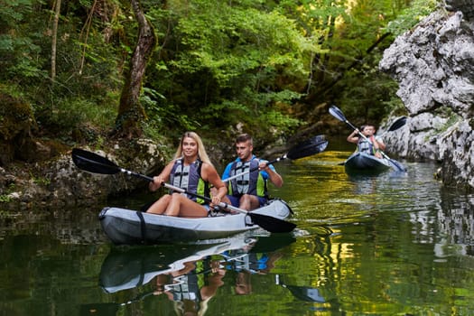 A group of friends enjoying having fun and kayaking while exploring the calm river, surrounding forest and large natural river canyons.