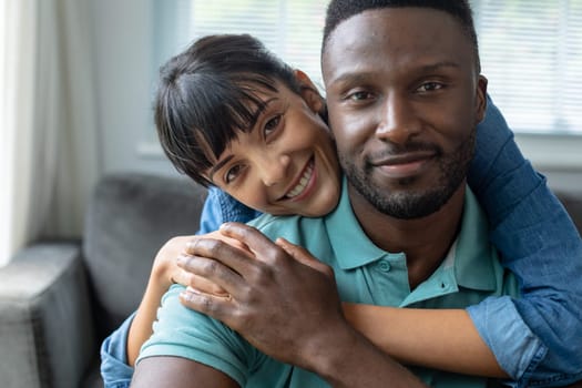 Portrait of smiling multiracial young couple spending leisure time together at home. unaltered, lifestyle, domestic life, togetherness, love.