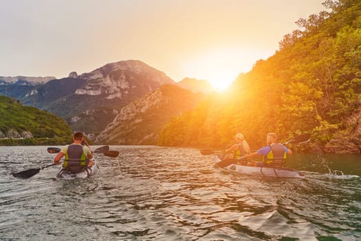 A group of friends enjoying fun and kayaking exploring the calm river, surrounding forest and large natural river canyons during an idyllic sunset