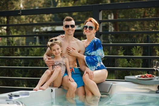 In summer, the family rests in the outdoor hot tub.