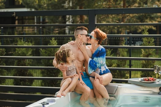 In summer, the family rests in the outdoor hot tub.