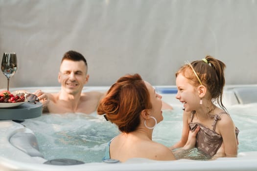 In summer, the family rests in the outdoor hot tub.