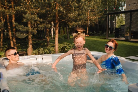 In summer, the family rests in the outdoor hot tub.