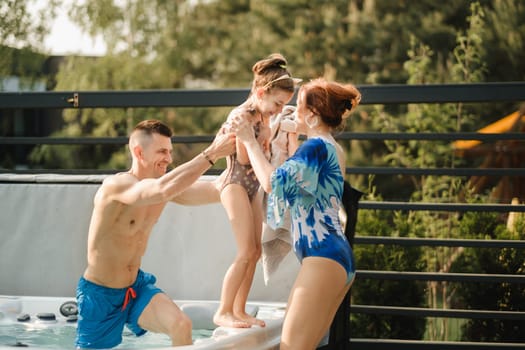 In summer, dad takes the child out of the outdoor pool.