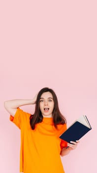 Captivating Reading Experience: Surprised Woman with Hand on Head, Engrossed in a Book with an Intriguing Genre - Fascination and Immersion Concept on Pink Background