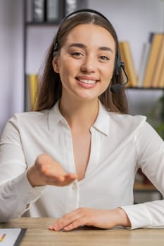 POV portrait of business woman wearing headset, freelance worker call center or support service operator helpline, having pleasant talk with client, colleague communication support at office. Vertical