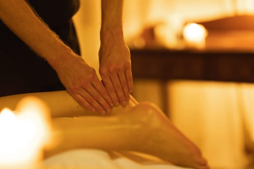 Massage in spa salon - a therapist massaging the foot of a woman client. Mid shot