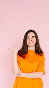 Positive Affirmation: Lovely Woman Pointing Thumb at Empty Space - Encouraging Positivity and Possibilities, Isolated on Pink Background