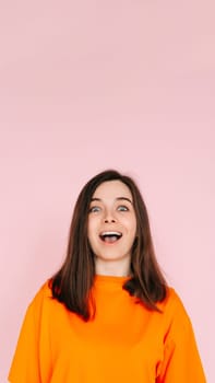 Energetic Expression: Impressed and Cheerful Woman with Open Mouth - Vibrant Emotion and Enthusiasm Captured on Pink Background