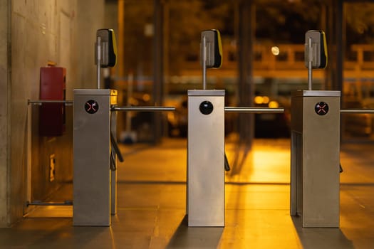 Access turnstiles from the subway in the late evening. Mid shot