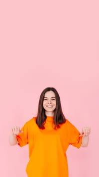 Surprised Woman Holding White Promo Paper for Unexpected Best Deal Offer. Expressive Shock and Excitement. Isolated on Pink Background. Perfect for Advertising, Marketing, and Promotional Concepts.