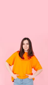 Joyful and Charming Young Woman with a Radiant Smile, Hands in Pockets. Contentment and Happiness. Isolated on Pink Background. Perfect for Lifestyle, Happiness, and Positive Vibes Concept.