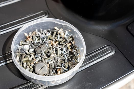 Metal fasteners, bolts, screws, nuts, washers in a box in the workshop.