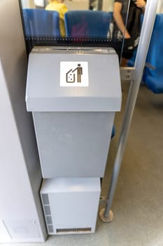A dumpster on the train. a special garbage can on the train for passengers to throw out garbage during the trip. Care about cleanliness.. A container for collecting garbage in a suburban train car.