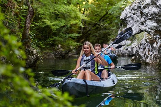 A group of friends enjoying having fun and kayaking while exploring the calm river, surrounding forest and large natural river canyons.