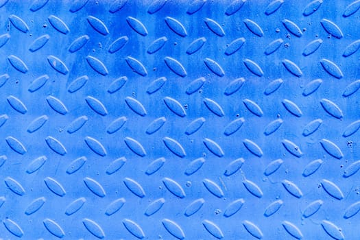The background of the corrugated iron sheet is blue. Textured abstract blue background with copy space