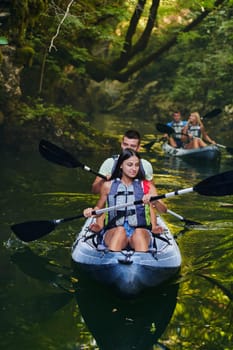 A group of friends enjoying having fun and kayaking while exploring the calm river, surrounding forest and large natural river canyons.