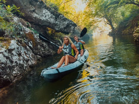 A young couple enjoying an idyllic kayak ride in the middle of a beautiful river surrounded by forest greenery.