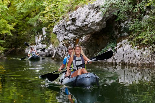 A group of friends enjoying having fun and kayaking while exploring the calm river, surrounding forest and large natural river canyons.