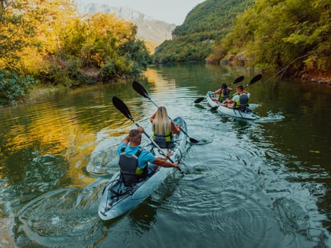 A group of friends enjoying having fun and kayaking while exploring the calm river, surrounding forest and large natural river canyons.