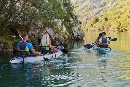 A group of friends enjoying having fun and kayaking while exploring the calm river, surrounding forest and large natural river canyons.