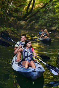 A group of friends enjoying having fun and kayaking while exploring the calm river, surrounding forest and large natural river canyons.