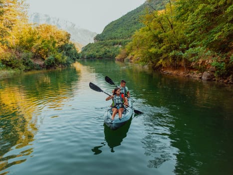 A group of friends enjoying fun and kayaking exploring the calm river, surrounding forest and large natural river canyons during an idyllic sunset