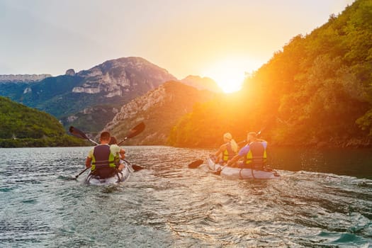 A group of friends enjoying fun and kayaking exploring the calm river, surrounding forest and large natural river canyons during an idyllic sunset