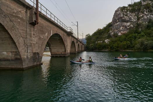 A group of friends enjoying having fun and kayaking while exploring the calm river, surrounding forest and large natural river canyons.