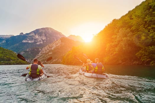 A group of friends enjoying fun and kayaking exploring the calm river, surrounding forest and large natural river canyons during an idyllic sunset