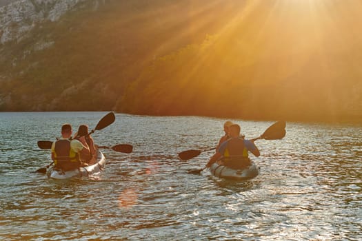 A group of friends enjoying fun and kayaking exploring the calm river, surrounding forest and large natural river canyons during an idyllic sunset