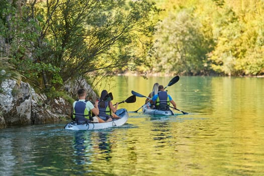 A group of friends enjoying having fun and kayaking while exploring the calm river, surrounding forest and large natural river canyons.