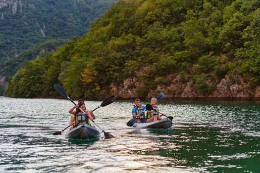 A group of friends enjoying having fun and kayaking while exploring the calm river, surrounding forest and large natural river canyons.