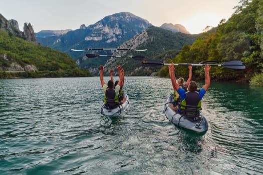 A group of friends enjoying fun and kayaking exploring the calm river, surrounding forest and large natural river canyons during an idyllic sunset